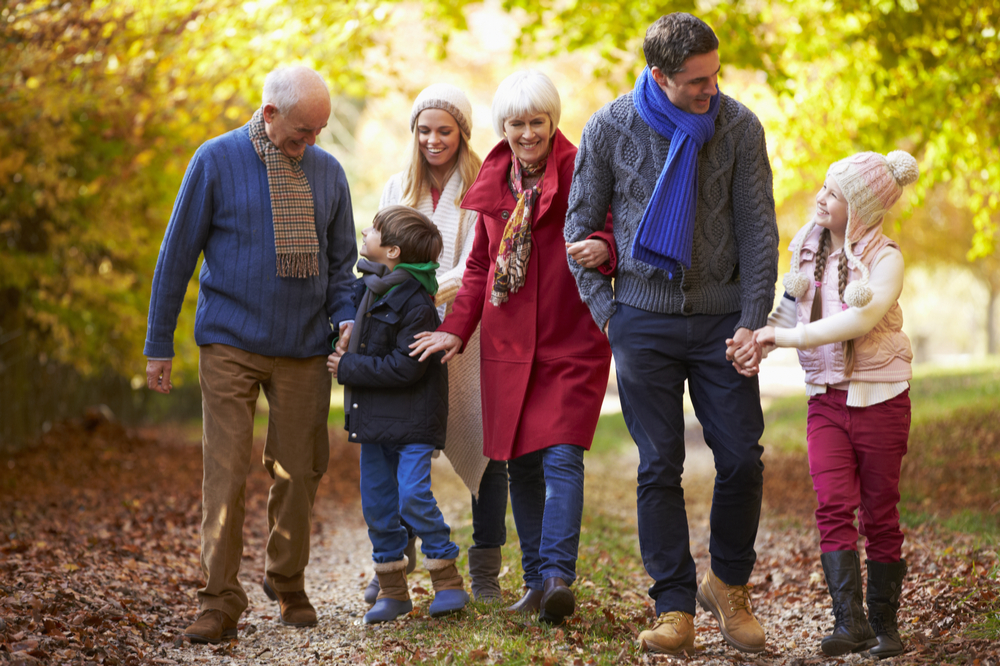 Multi-generation family walking along autumn path